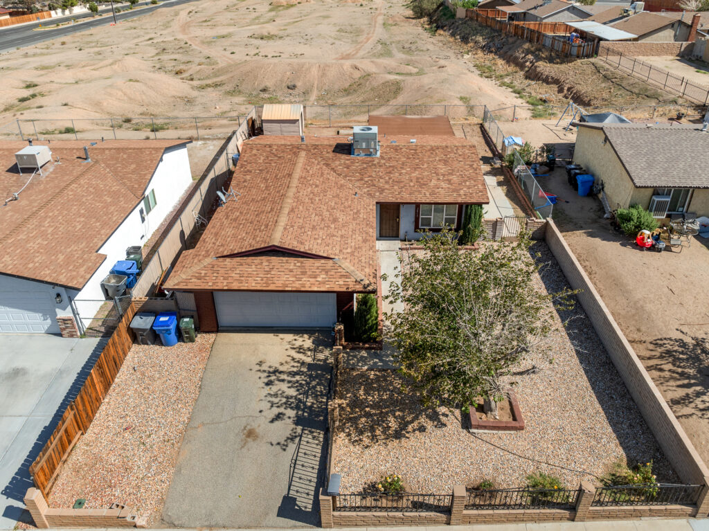 Aerial view of the single-story home at 2013 Rushmore Dr in Barstow with attached garage and fenced yard